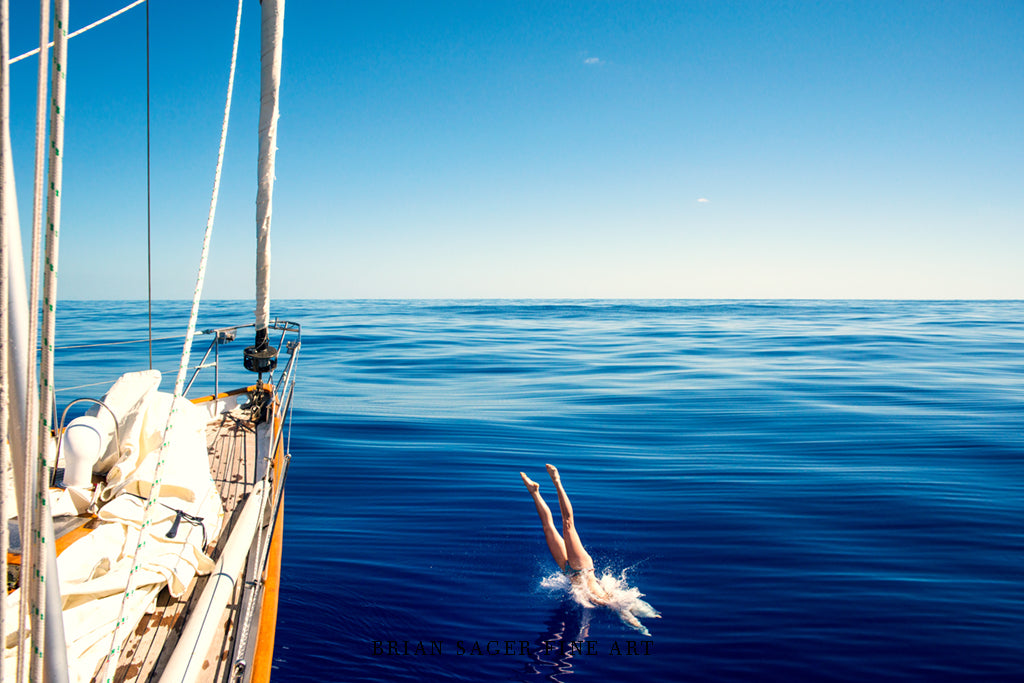 Framed nautical fine art metal print of a woman diving into the ocean offshore by Brian Sager